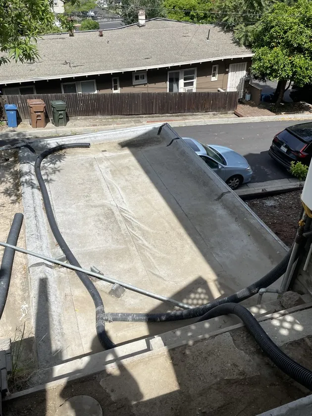 Roofer installing a flat roof membrane on a Bay Area home