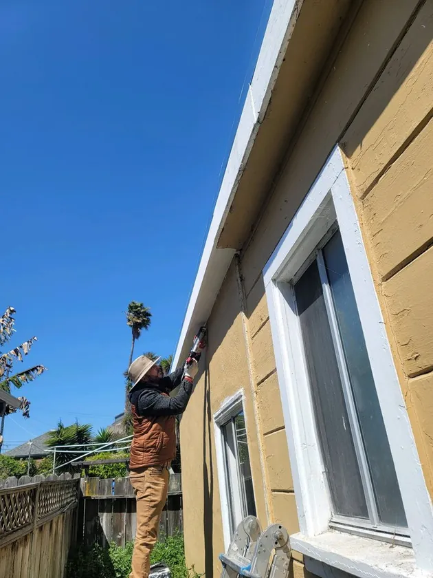 New gutter and downspout installed along the eave